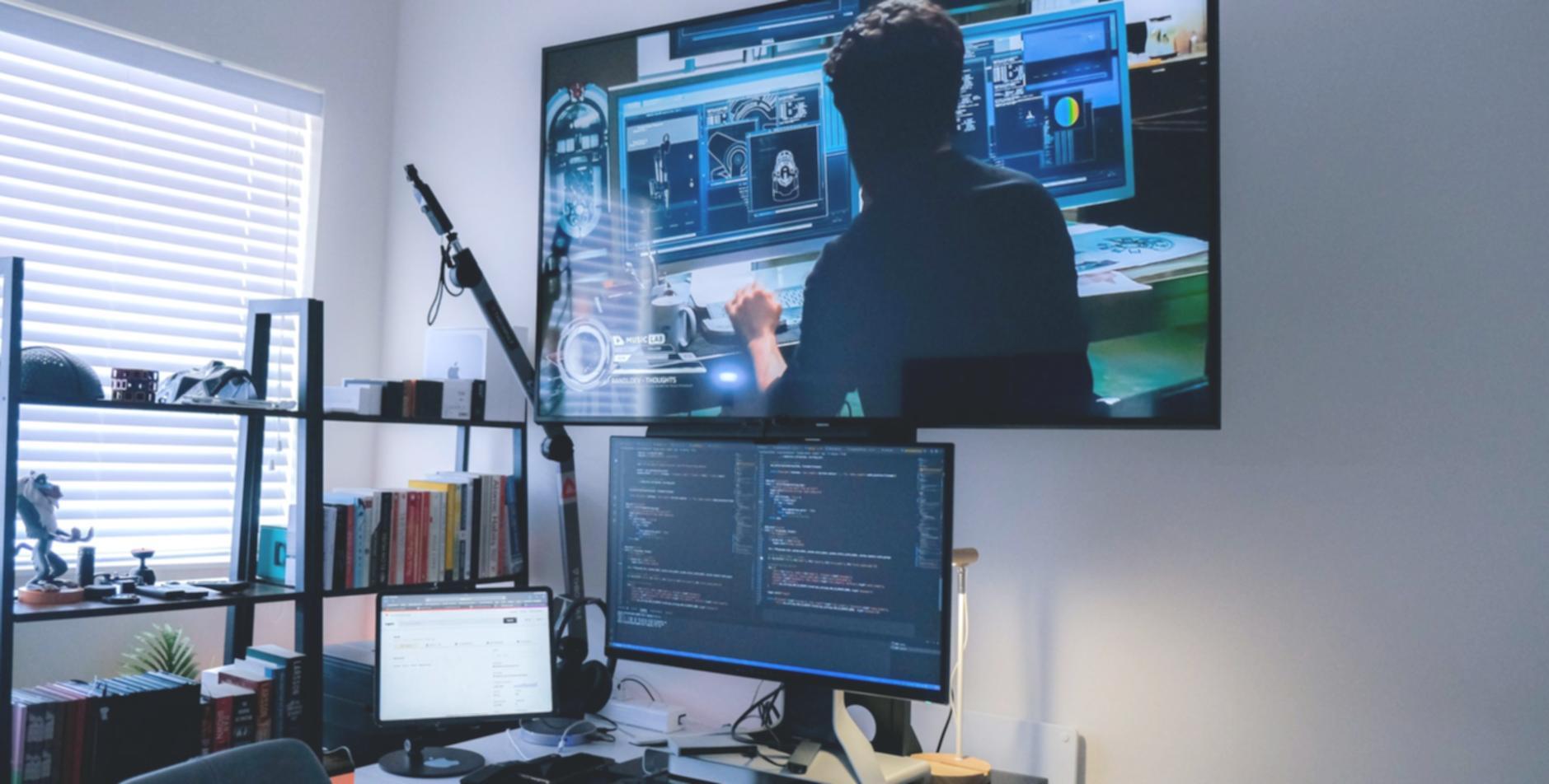 Sessione di programmazione con codice reale su monitor multipli